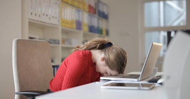 față obosită de fată pe tastatura laptopului